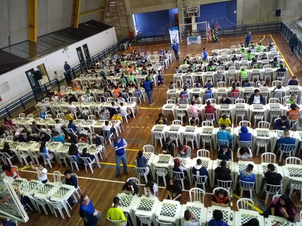 Dezenas de alunos da DRE Ipiranga sentados frente ao tabuleiro de xadrez